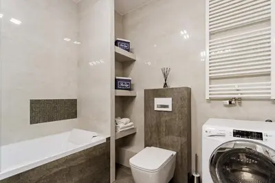 a bathroom with a washing machine and a toilet at Apartments Kraków Zablocie by Noclegi Renters in Kraków
