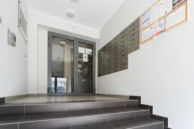 a staircase in a building with a glass door at Apartments Kraków Zablocie by Noclegi Renters in Kraków