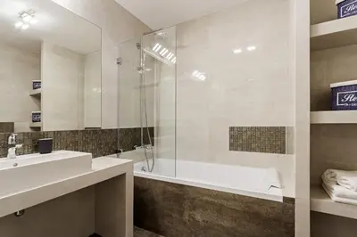 a bathroom with a tub and a sink and a shower at Apartments Kraków Zablocie by Noclegi Renters in Kraków