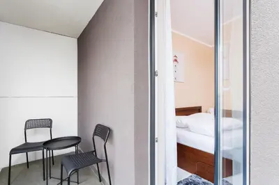 a room with two chairs and a bed at Apartments Kraków Zablocie by Noclegi Renters in Kraków