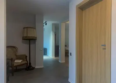 a hallway with a chair and a lamp in a room at Aparthotel STUDIO in Kraków