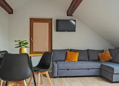 a living room with a couch and a table and chairs at Aparthotel STUDIO in Kraków