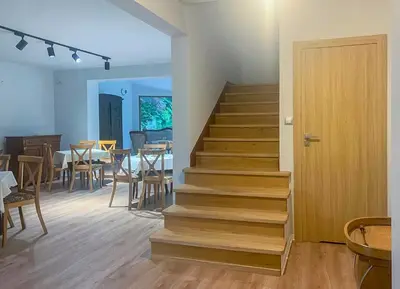a staircase in a room with a table and chairs at Aparthotel STUDIO in Kraków
