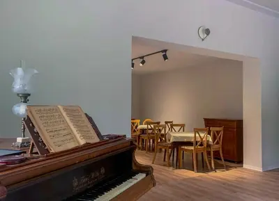 a room with a piano and a table and chairs at Aparthotel STUDIO in Kraków