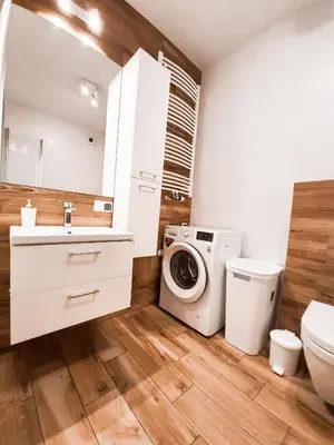 a bathroom with a washing machine and a washer at Apartament Kraków Arena in Kraków