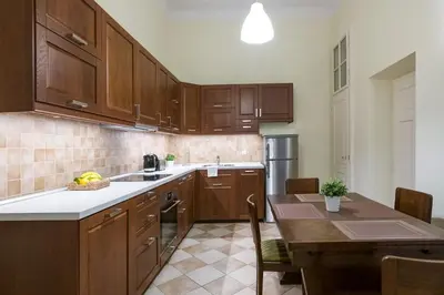a kitchen with wooden cabinets and a table and a kitchen with a tableablish at Belle Epoque II, luxury suite 50m to Main Square in Kraków