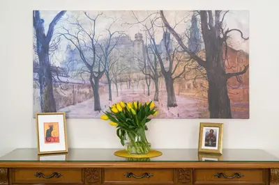 a vase with yellow flowers on a dresser with a painting at Belle Epoque II, luxury suite 50m to Main Square in Kraków