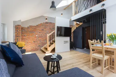 a bedroom with a bed with a desk and a chair at InPoint Old Town Comfort Apartments Self Check-in in Kraków