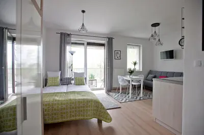 a bedroom with a bed and a living room at Apartament Nad Wisłą - Pianissimo in Kraków