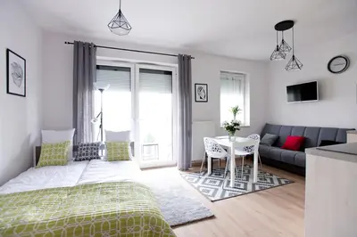 a bedroom with a bed and a couch and a table at Apartament Nad Wisłą - Pianissimo in Kraków