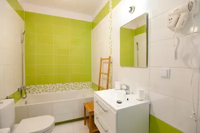 a bathroom with a toilet and a sink and a tub at Apartament Nad Wisłą - Pianissimo in Kraków