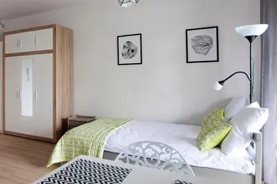 a bedroom with a bed and a lamp and a door at Apartament Nad Wisłą - Pianissimo in Kraków