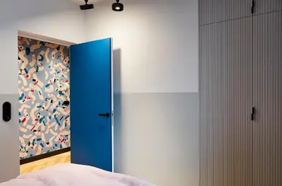 a bedroom with a blue door and a painting on the wall at Rajska Blue Luxury Apartment in Kraków