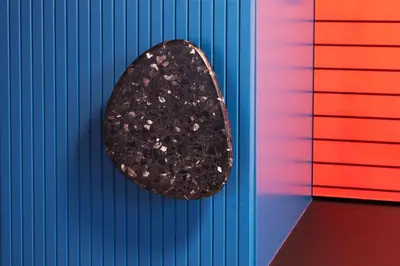 a piece of black rock on a colorful wall at Rajska Blue Luxury Apartment in Kraków