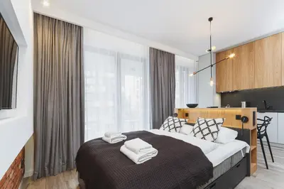 a bedroom with a large bed with towels on it at Apartments GO Rakowicka by Noclegi Renters in Kraków