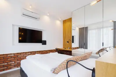 a bedroom with two beds and a tv on the wall at Apartments GO Rakowicka by Noclegi Renters in Kraków