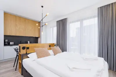 a bedroom with two beds and a large window at Apartments GO Rakowicka by Noclegi Renters in Kraków