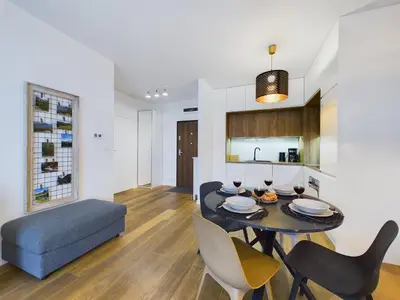 a dining room and kitchen with a table and chairs at Apartments GO Rakowicka by Noclegi Renters in Kraków