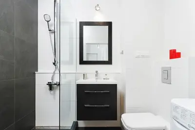 a bathroom with a sink and a toilet and a mirror at Apartments GO Rakowicka by Noclegi Renters in Kraków