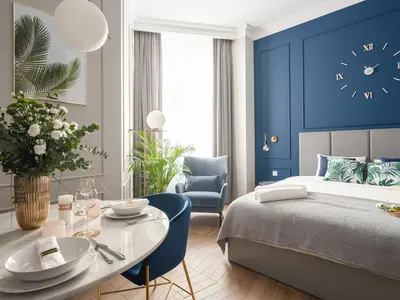 a bedroom with a bed and a table and a clock at Luxury Gold Cracow City Centre 3min Main Sq Old Town in Kraków