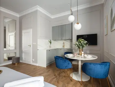 a kitchen and dining room with a table and blue chairs at Luxury Gold Cracow City Centre 3min Main Sq Old Town in Kraków