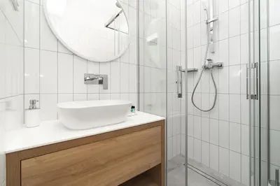 a white bathroom with a sink and a shower at Loft Apartment Cracow Old Town 3min Main Sq in Kraków