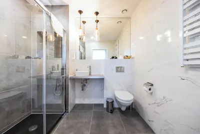 a bathroom with a shower and a toilet and a sink at Platinum Suites in Kraków