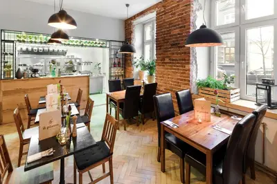 a restaurant with wooden tables and chairs and a brick wall at Platinum Suites in Kraków