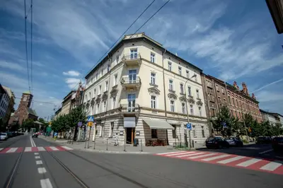 a large white building on the corner of a street at Platinum Suites in Kraków