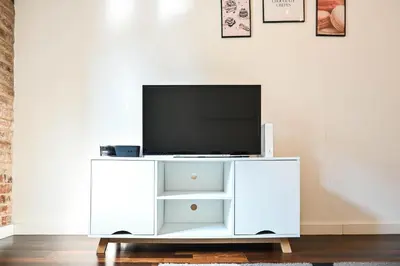 a white entertainment center with a flat screen tv on it at D&A Apartmetns Lenartowicza in Kraków