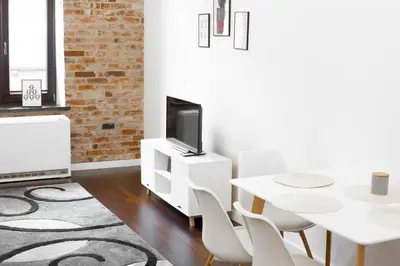 a living room with a white table and a tv at D&A Apartmetns Lenartowicza in Kraków