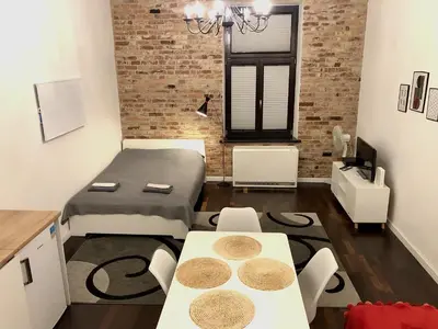 a room with a bed and a table and chairs at D&A Apartmetns Lenartowicza in Kraków