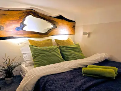 a bedroom with a bed with green and white pillows at Studio blisko Wawelu in Kraków