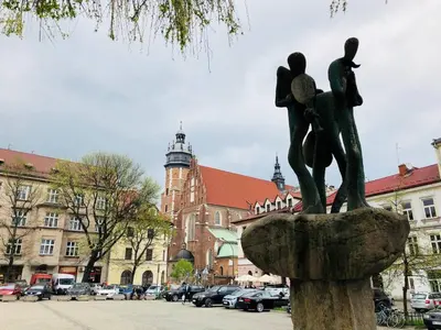 a statue of two people in a fountain in a city at Studio blisko Wawelu in Kraków