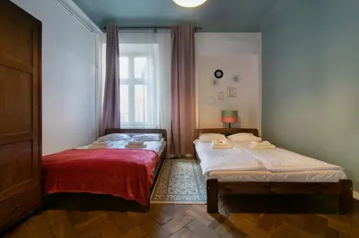 two beds in a room with a window at Cozy Apartments Krakowska Street, Kazimierz District in Kraków