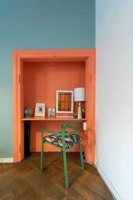 a green chair in a room with a desk at Cozy Apartments Krakowska Street, Kazimierz District in Kraków