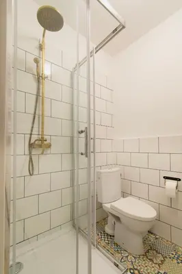 a bathroom with a toilet and a glass shower at Cozy Apartments Krakowska Street, Kazimierz District in Kraków