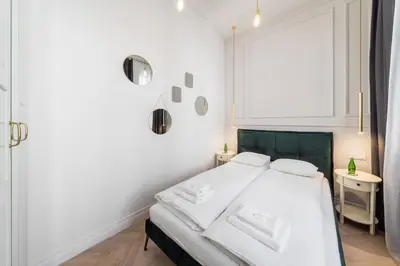 a white bedroom with a bed and a window at Apartament Deluxe Old Town św. Krzyża WAWELOFTS in Kraków