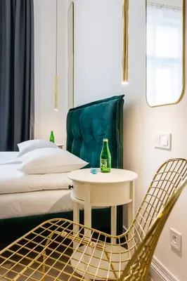 a room with a bed and a table and a chair at Apartament Deluxe Old Town św. Krzyża WAWELOFTS in Kraków