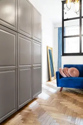 a room with a blue couch and a large closet at HOUSEHOST Apartment: Łazarza street in Kraków