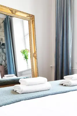 a mirror and two beds with towels on them at HOUSEHOST Apartment: Łazarza street in Kraków