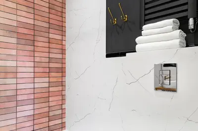 a bathroom with a stack of towels on a counter at HOUSEHOST Apartment: Łazarza street in Kraków