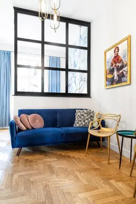 a living room with a blue couch and a table at HOUSEHOST Apartment: Łazarza street in Kraków