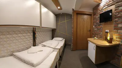 a hotel room with three beds and a television at Pokoje Wieliczka in Wieliczka