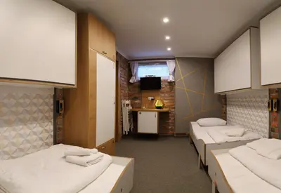 a dorm room with three beds and a kitchen at Pokoje Wieliczka in Wieliczka
