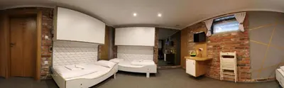 a room with two beds and a brick wall at Pokoje Wieliczka in Wieliczka