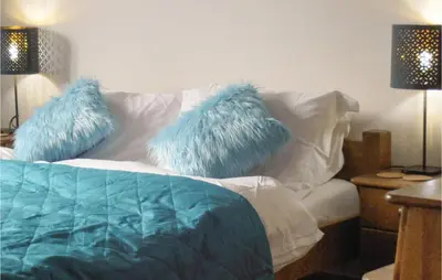 a white couch with blue pillows on top of it at One-Bedroom Holiday Home In Biadoliny Szlachecki in Biadoliny Szlacaheckie