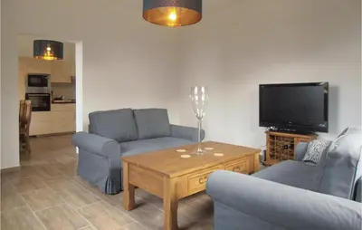 a living room with two couches and a tv at One-Bedroom Holiday Home In Biadoliny Szlachecki in Biadoliny Szlacaheckie