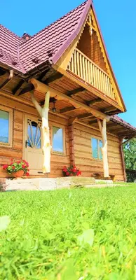 a wooden house with a roof on top of a yard at Domek Agroturystyczny na Putówce in Słopnice