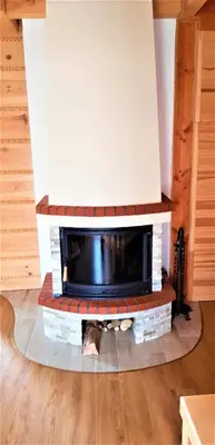 a living room with a fireplace in a house at Domek Agroturystyczny na Putówce in Słopnice